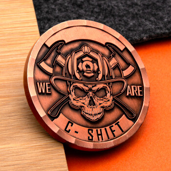 Antique copper firefighter challenge coin featuring a skull in a helmet with crossed axes and the text We Are C-Shift.