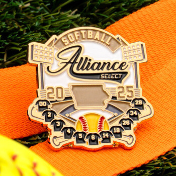 Softball Alliance Select 2025 lapel pin featuring a stadium design, Iowa state outline, and jerseys on an orange ribbon over grass.