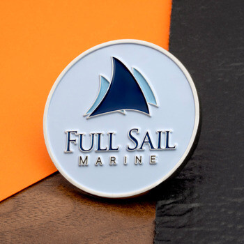 Circular Full Sail Marine challenge coin with a blue sailboat sail logo on a white background.