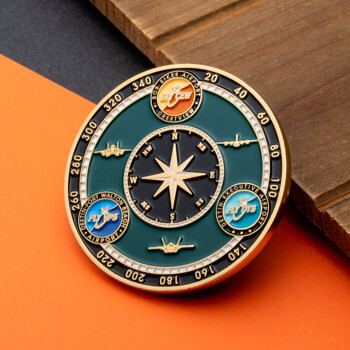 A circular green and gold challenge coin featuring a central compass rose, aircraft silhouettes, and airport logos for VPS, DTS, and CEW.