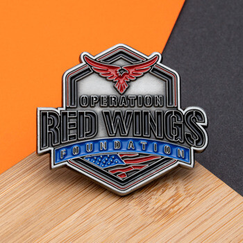 Shield-shaped lapel pin for Operation Red Wings Foundation featuring a red eagle, silver text, and American flag details.