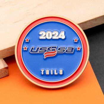 Round USSSA 2024 Tails challenge coin with blue and red enamel and gold trim.