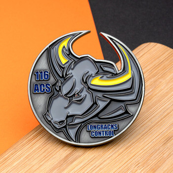 Bull head challenge coin with yellow accents and text reading 116 ACS Longracks Control on a silver finish.