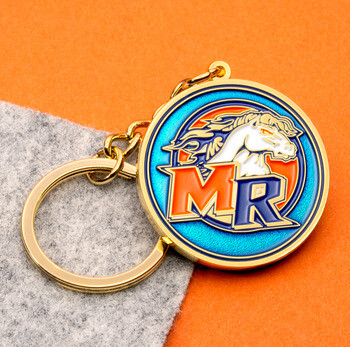 Gold metal keychain featuring a circular enamel medallion with a horse mascot and the letters MR on a blue background.
